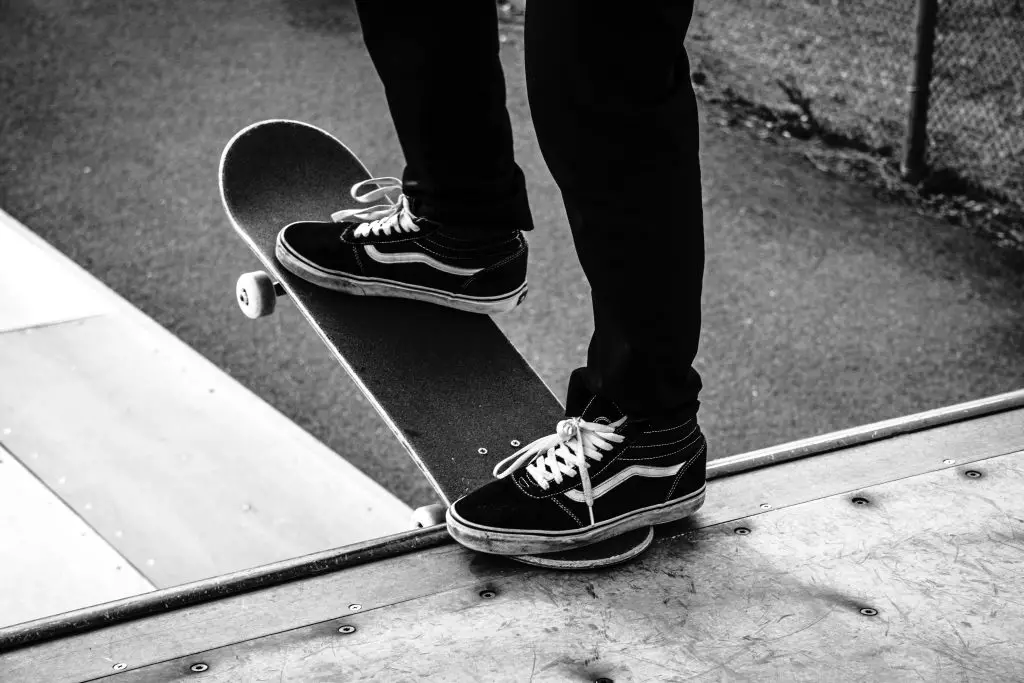 Image of a skateboarder ready to go down the ramp using a black skateboard. Source: harrison kugler, unsplash