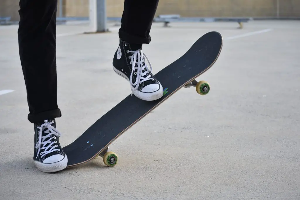 Image of a skateboarder stepping on his black skateboard. Source: mikolaj felinski unsplash