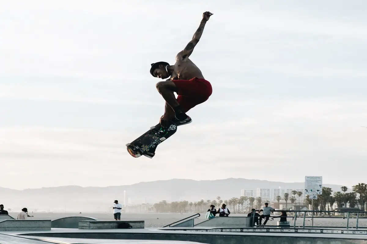 Image of a skater doing a high jump in a skatepark. Source: unsplash