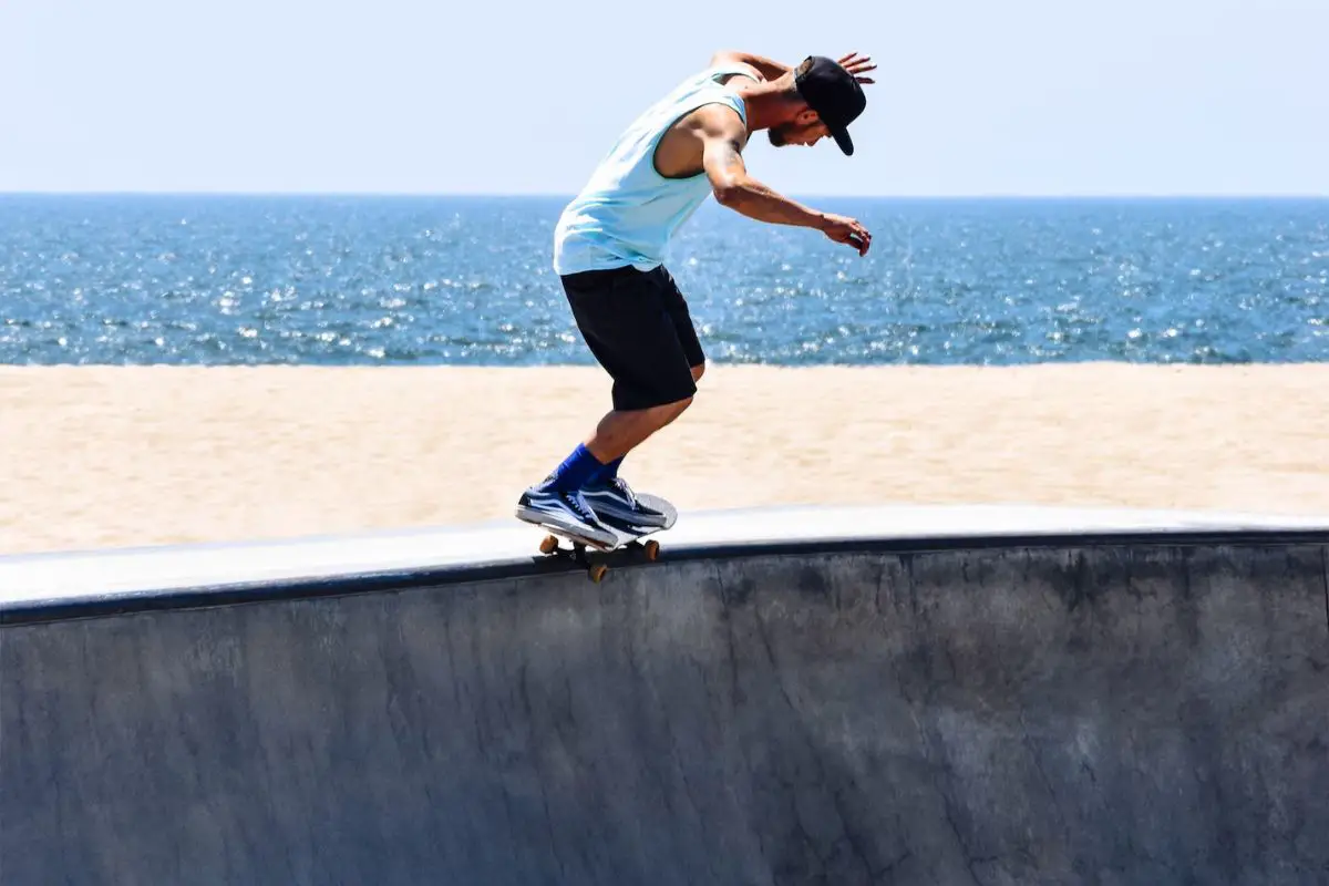 Image of a male skateboarder carve skateboarding in a skate bowl.