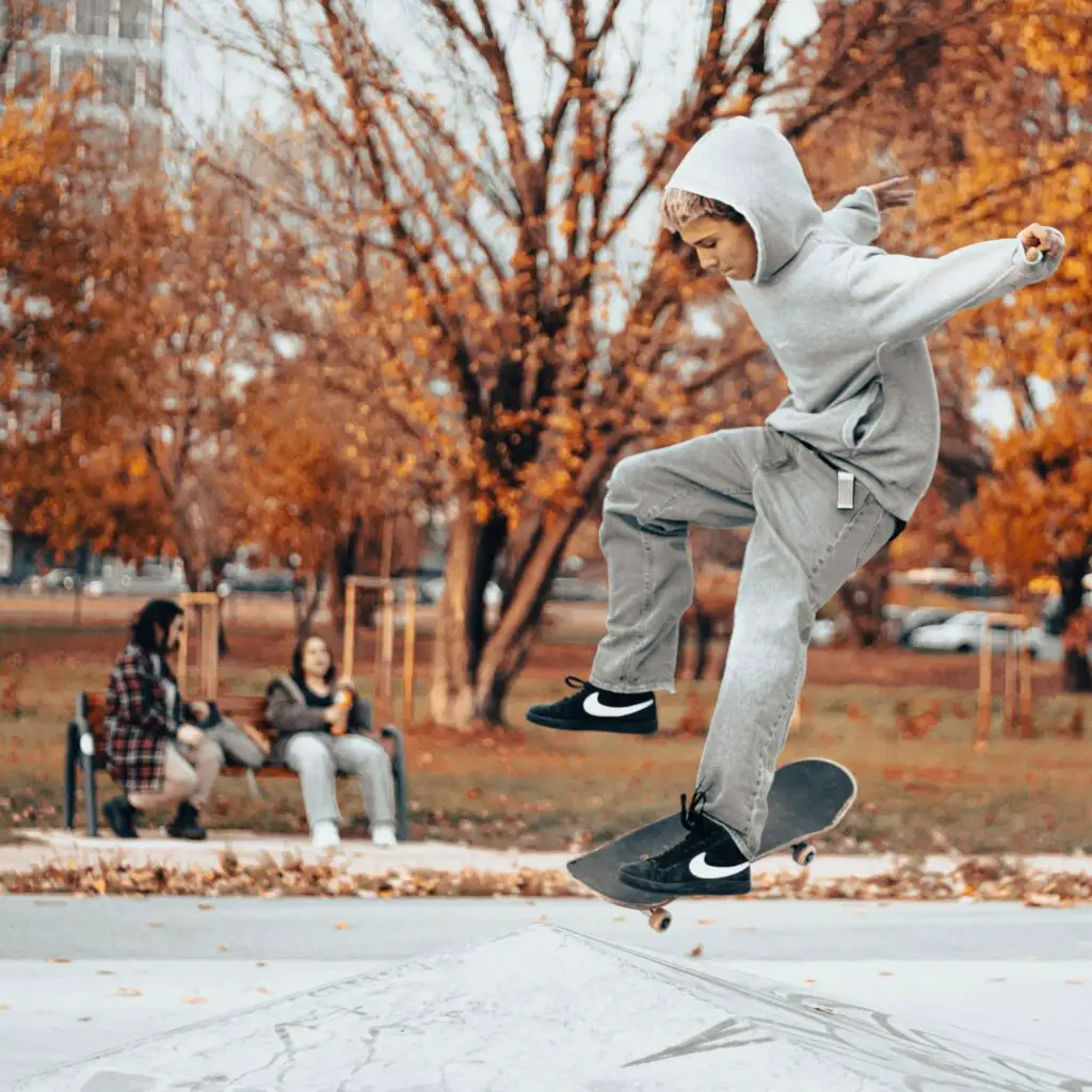 Image of a young male skateboarder skating in a park.