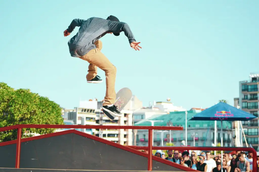 Image of a skateboarder doing a trick midair during a skate competition. Source: unsplash