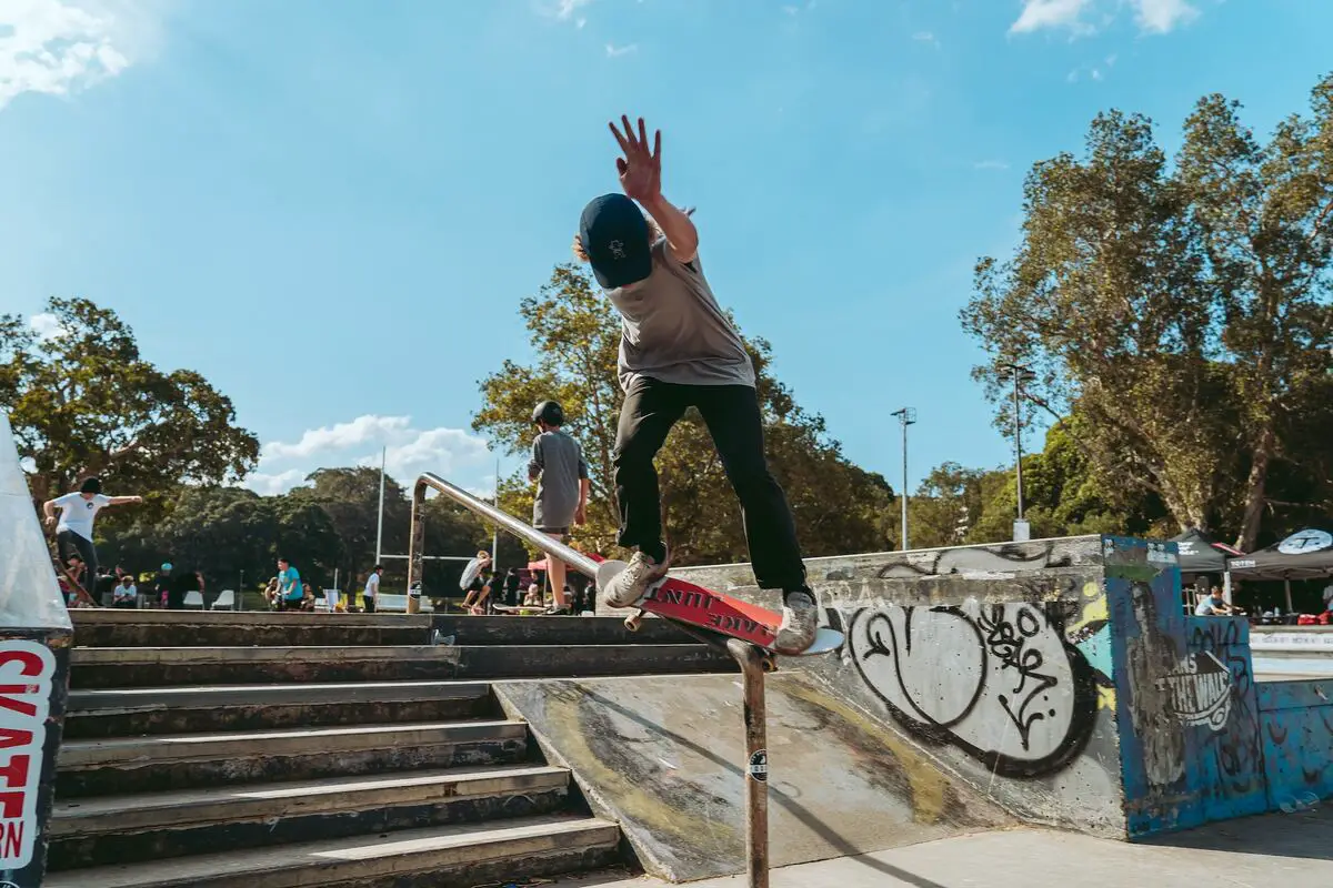 Image of a skater doing the darkslide skateboard trick on a railing. Source: unsplash