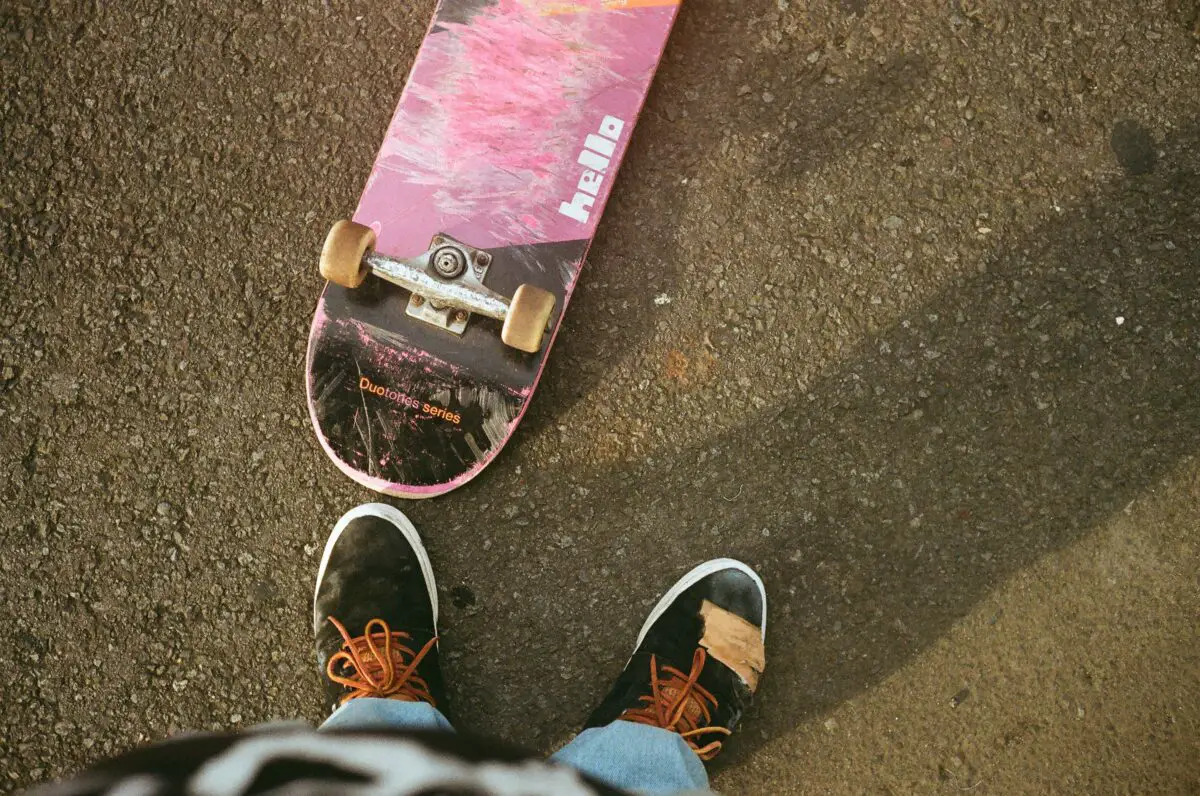 Image of a pink skateboard flipped on the floor.