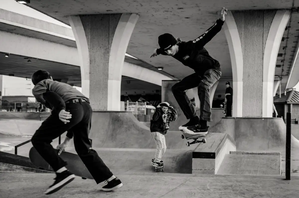Image of skateboarders skateboarding together in a skate park.