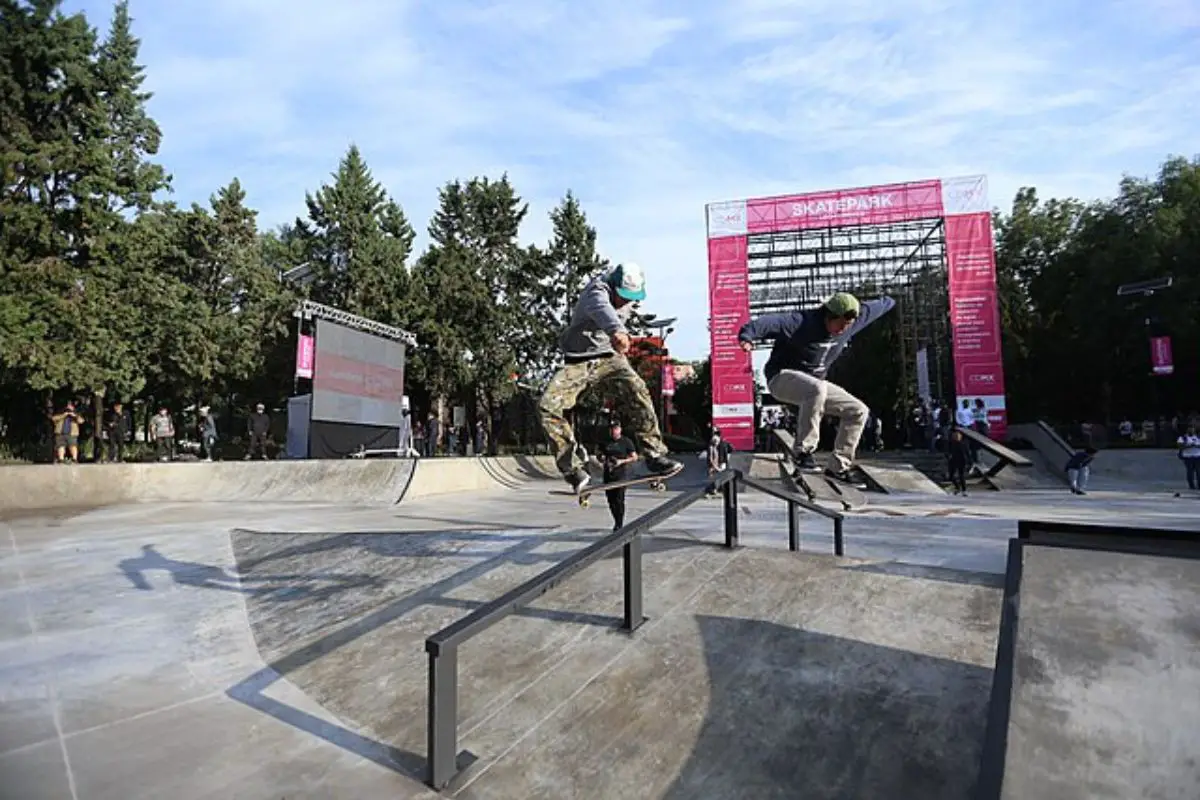 Image of some skaters doing free style tricks in a skate park.