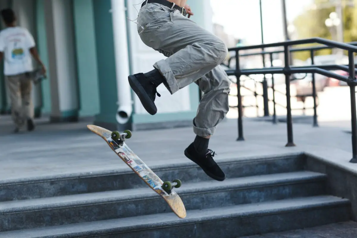 Image of a skateboarder going down the stairs with his skateboard.
