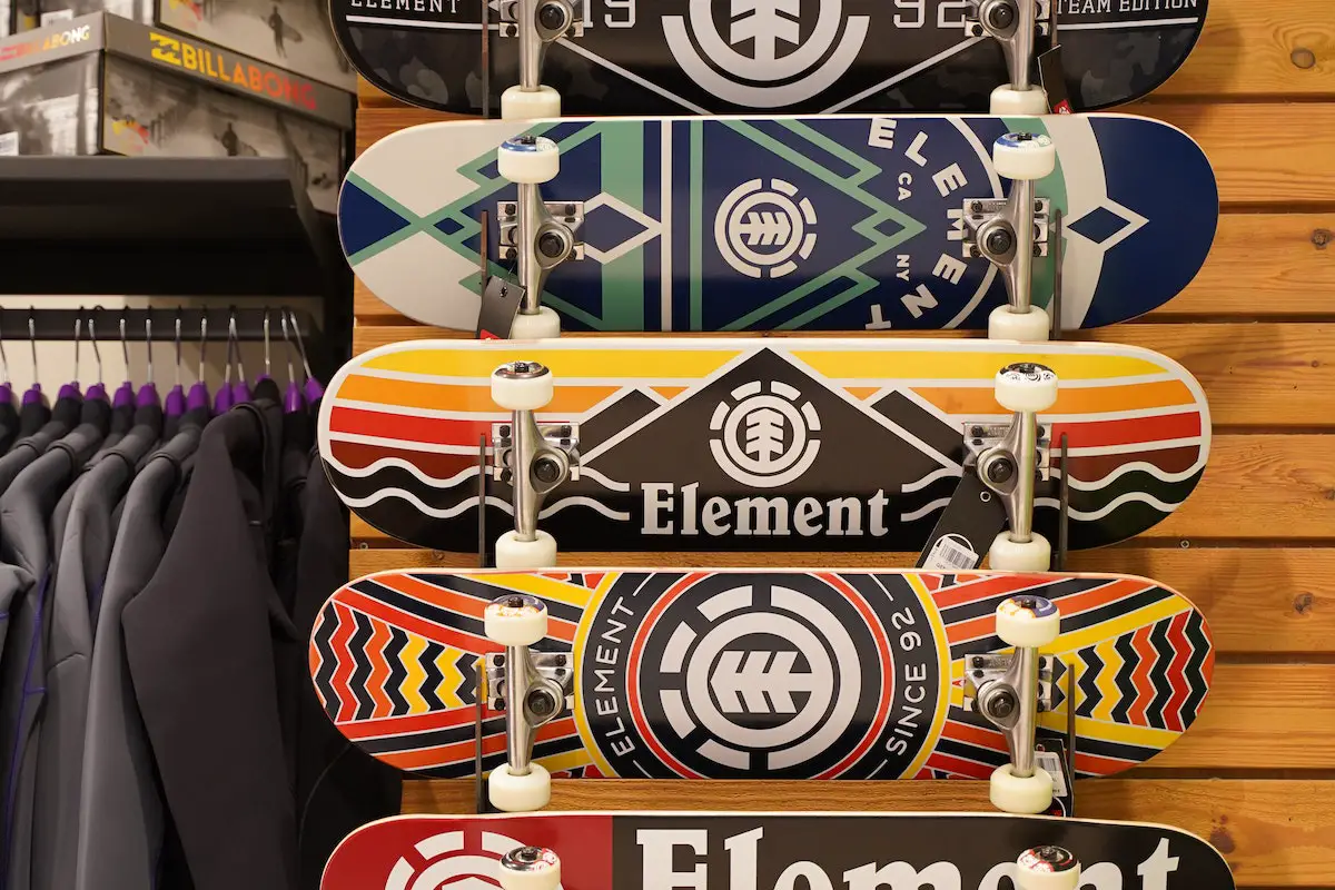 Image of skateboards hanging on a rack of a skate shop. Source: pexels
