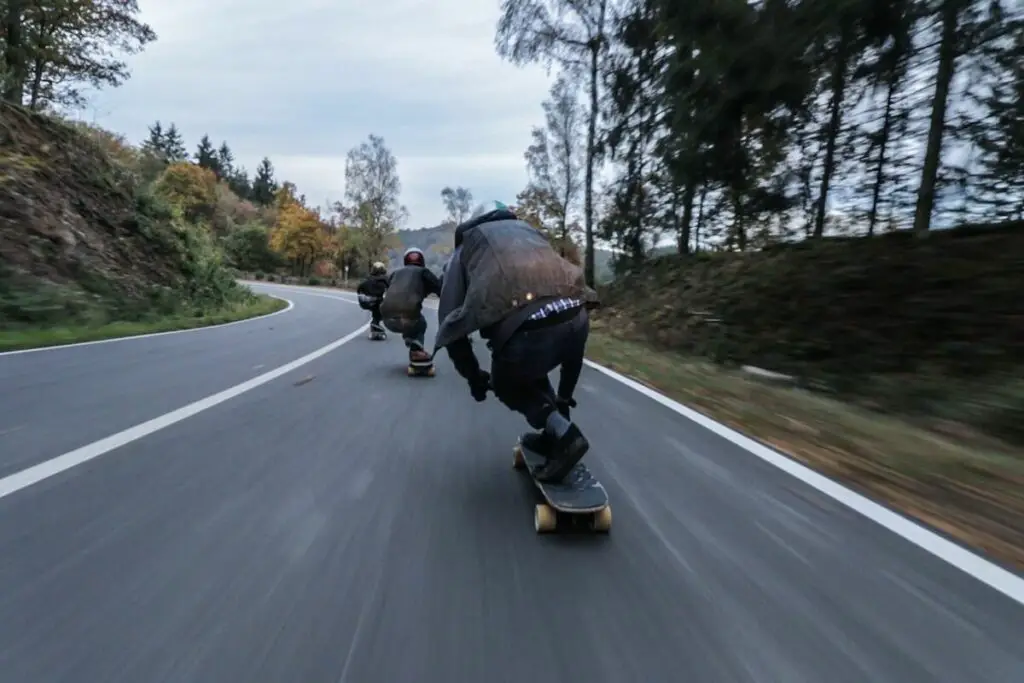 Image of skaters going fast downhill. Source: unsplash