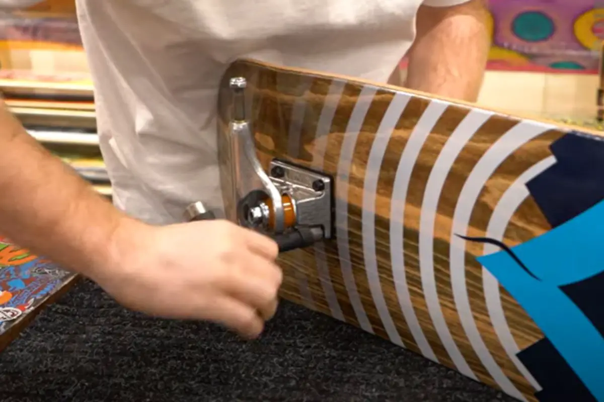 A snapshot of a male skater assembling a skateboard. Source: tactic boardshop youtube channel