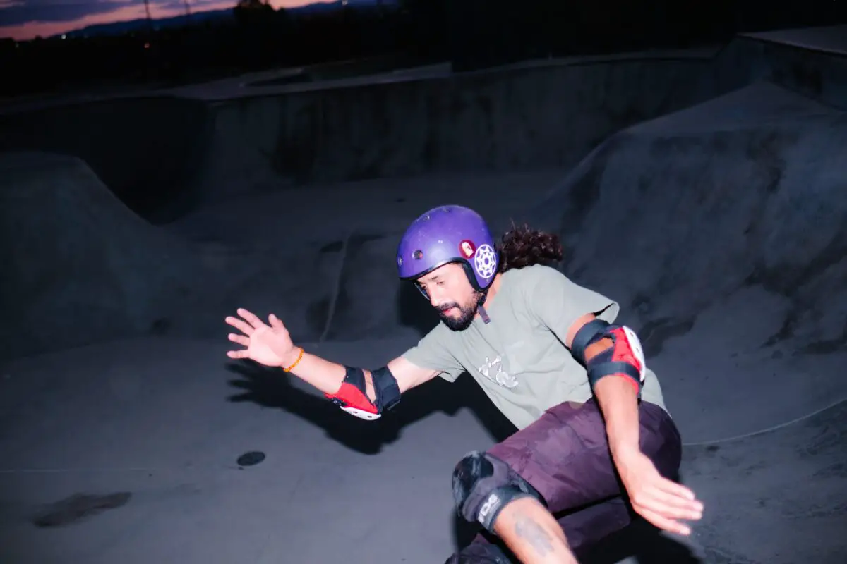 Image of a skateboarder wearing a purple skate helmet. Source: unsplash