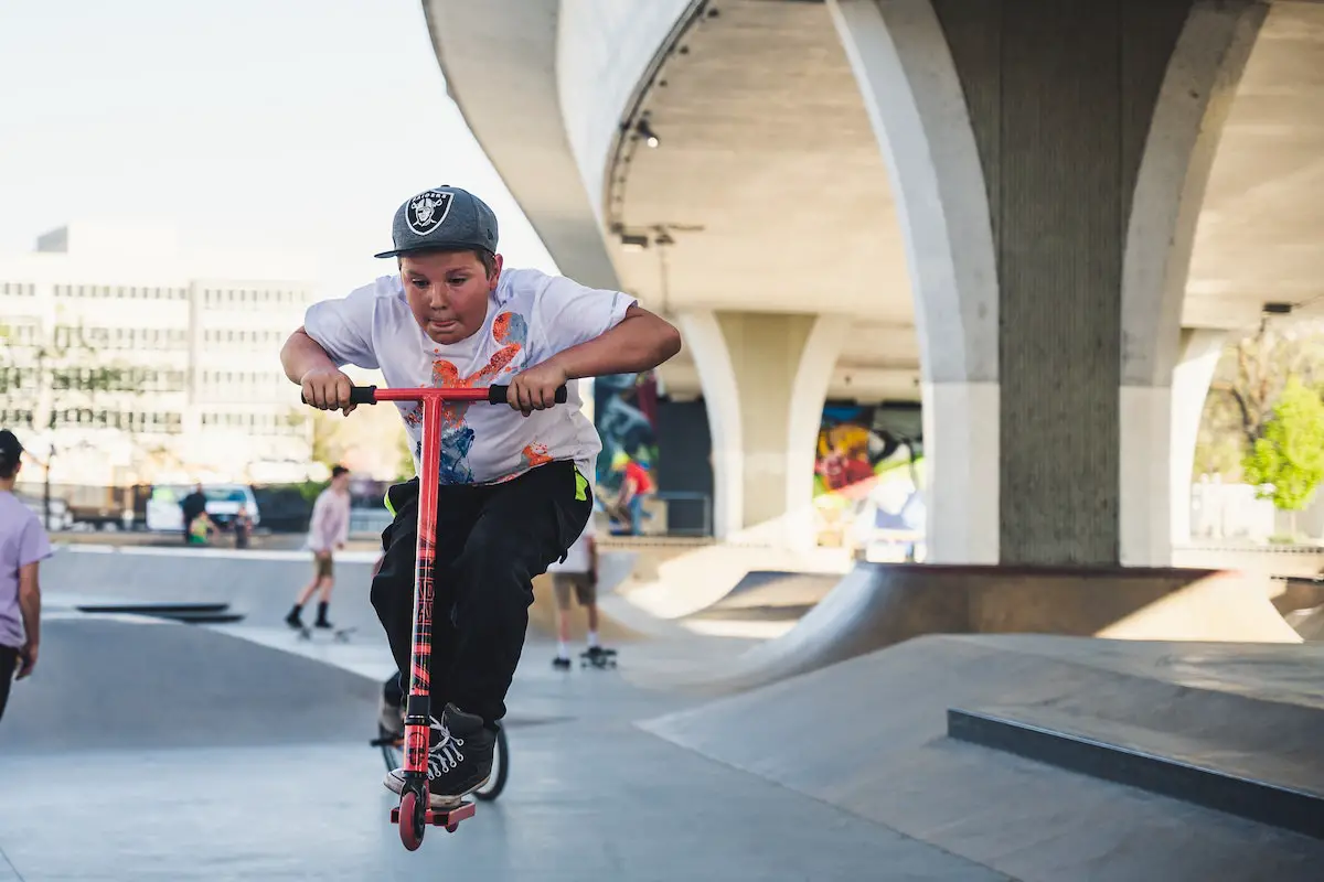 Image of a kid riding a scooter in a local skatepark. Source: pexels