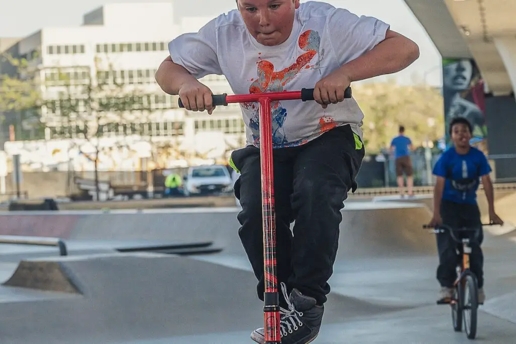Image of a kid riding a scooter in a skatepark. Source: pexels