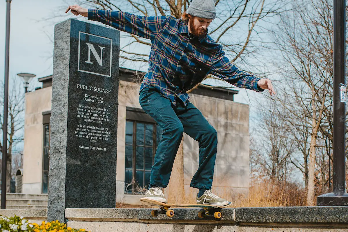 Image of a skater doing a trick on gray concrete. Source: pexels