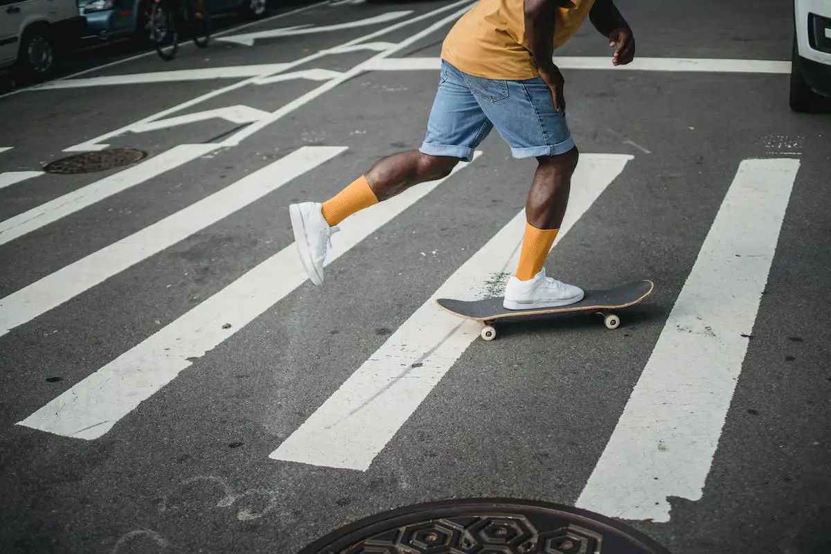 Image of a skater pushing on a skateboard. Source: pexels