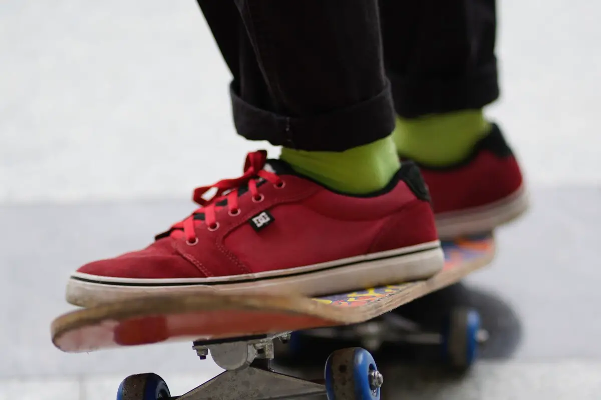 Image of a skater wearing red dc skate shoes while riding a skateboard. Source: unsplash