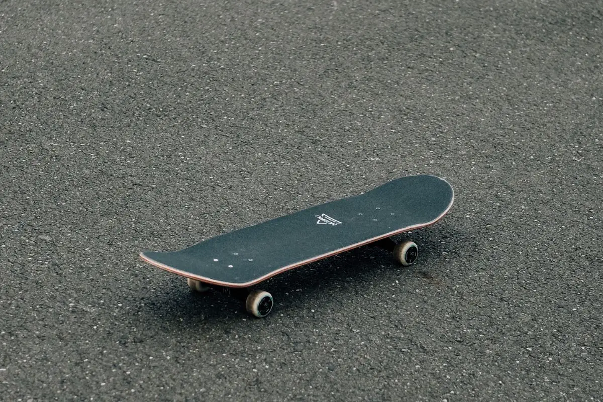 Image of a black skateboard on a gray concrete floor. Source: unsplash