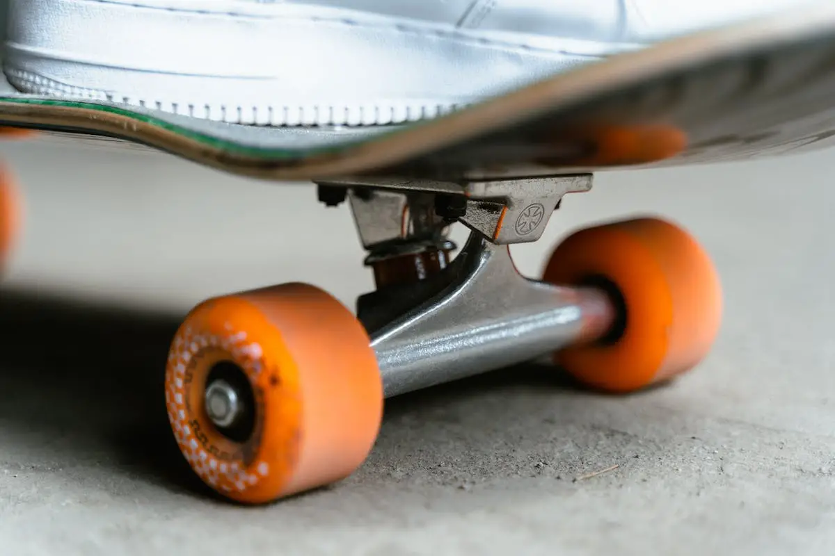 Image of a skateboard with orange wheels. Source: pexels