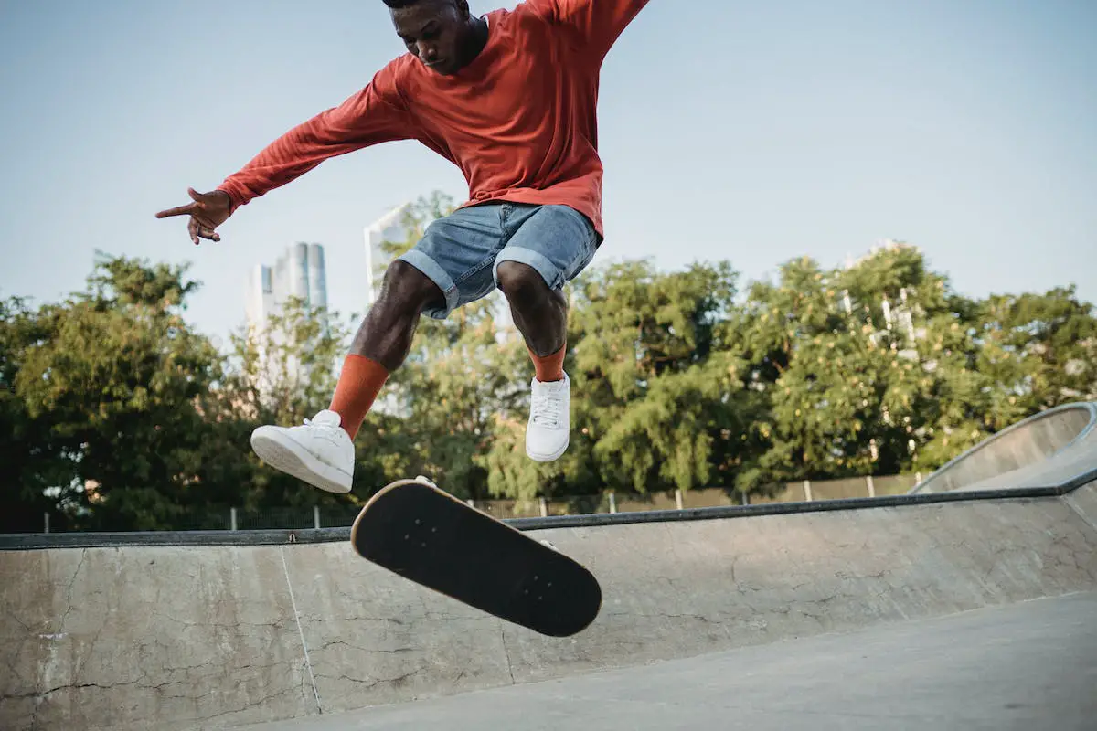 Image of a skater doing a skateboard trick midair. Source: pexels