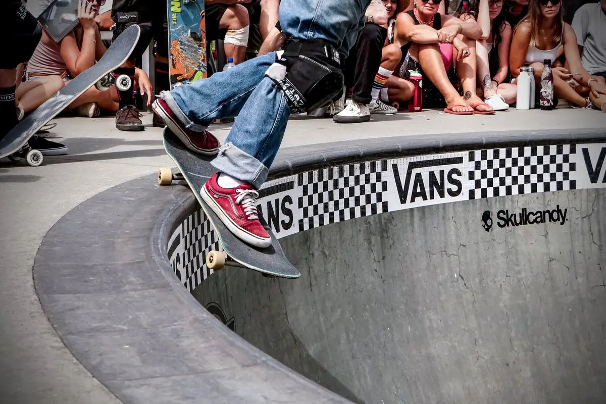 Image of a skater going down a skating bowl while wearing vans skate shoes. Source: unsplash