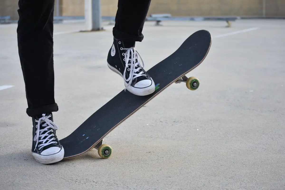 Image of a skater with black hi-top converse shoes doing tricks on a skateboard. Source: unsplash